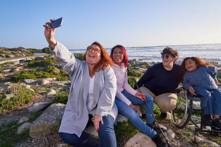 Group of diverse friends taking a photo by the beach
